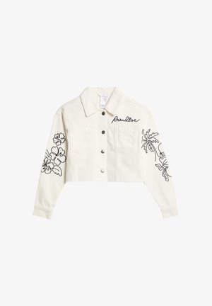 Giacca di jeans tagliata in bianco sporco con ricami floreali neri sulle maniche, chiusura con bottoni e due tasche sul petto.