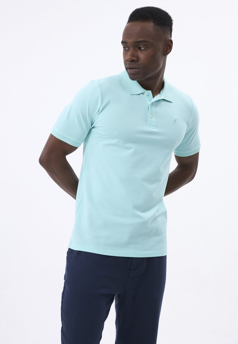 Polo shirt azzurro chiaro realizzato in morbido cotone, dotato di un colletto con tre bottoni, maniche corte e un piccolo logo sul petto.