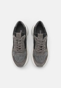 Par de zapatillas de tela y gamuza en gris y negro con suelas y cordones blancos, vistas desde arriba sobre un fondo blanco.