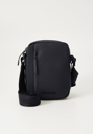 Borsa a tracolla nera con una finitura opaca e liscia. Caratterizzata da una chiusura con zip, una tracolla regolabile e un logo in rilievo sul davanti.