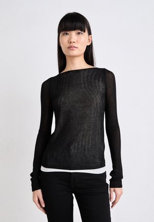 Svart langermet strikket topp med båthals, gjennomsiktig tekstur og hvit kantdetalj, kombinert med svarte bukser.