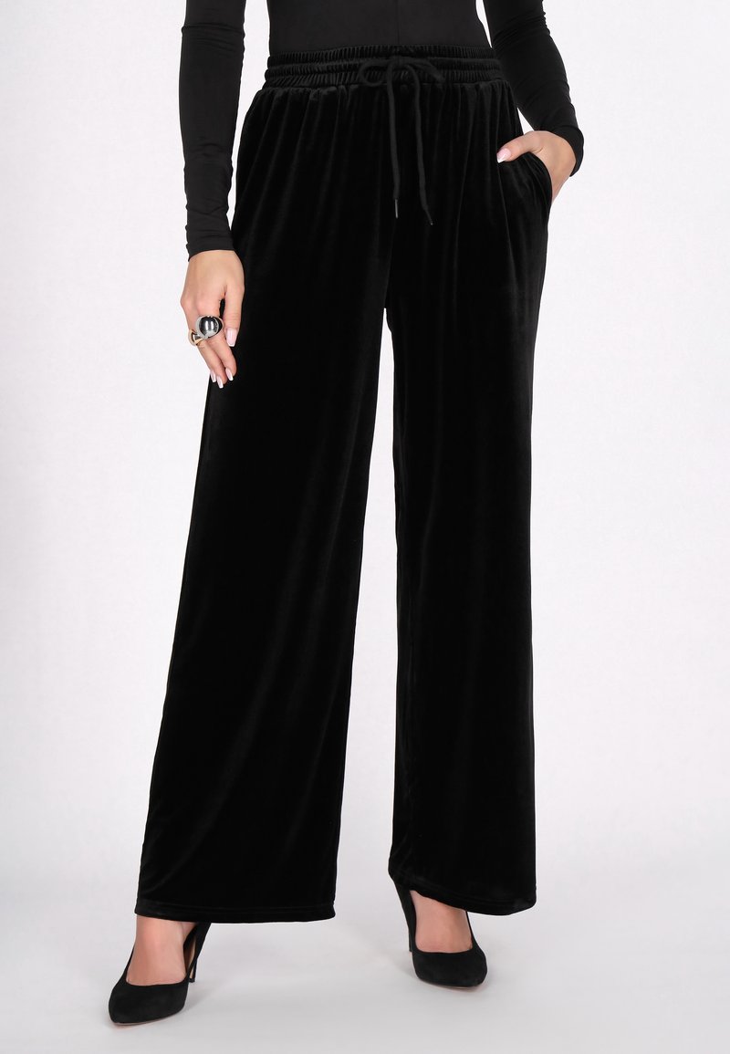 Fekete bársony széles szárú nadrág, rugalmas derékkal és húzózsinórral, oldalzsebekkel és puha, sima textúrával.