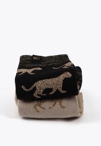Två par strumpor staplade: ett par svarta med gyllene leopardmönster, det andra beige med matchande leoparddesign, med en texturerad yta.