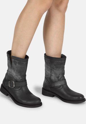 Black leather ankle boots with a matte finish, rounded toe, side strap with buckle detail, and low stacked heel.