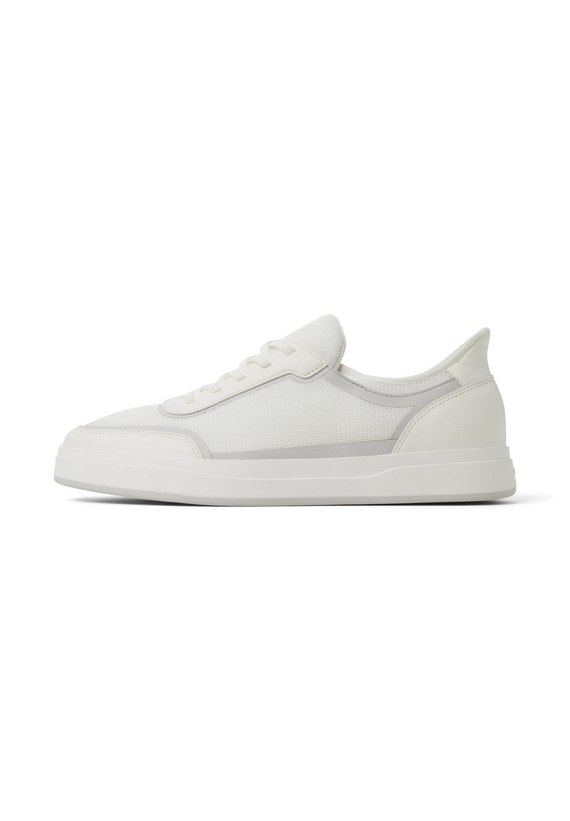 Sneaker bianco con parte superiore in rete testurizzata, dettagli in pelle liscia e punta arrotondata; suola piatta in gomma con un sottile dettaglio sul tacco.