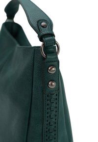 Groene leren handtas met een gestructureerde afwerking, voorzien van een brede schouderband, decoratieve studs en een sleufaccent aan de zijkant.