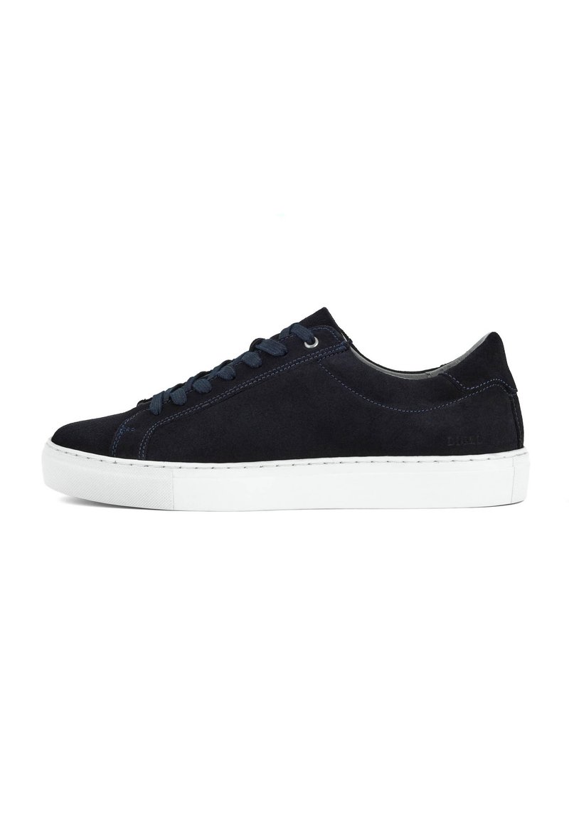Navy suede sneaker with white rubber sole, round toe, and contrasting blue stitching. Features flat laces and subtle branding on the side.
