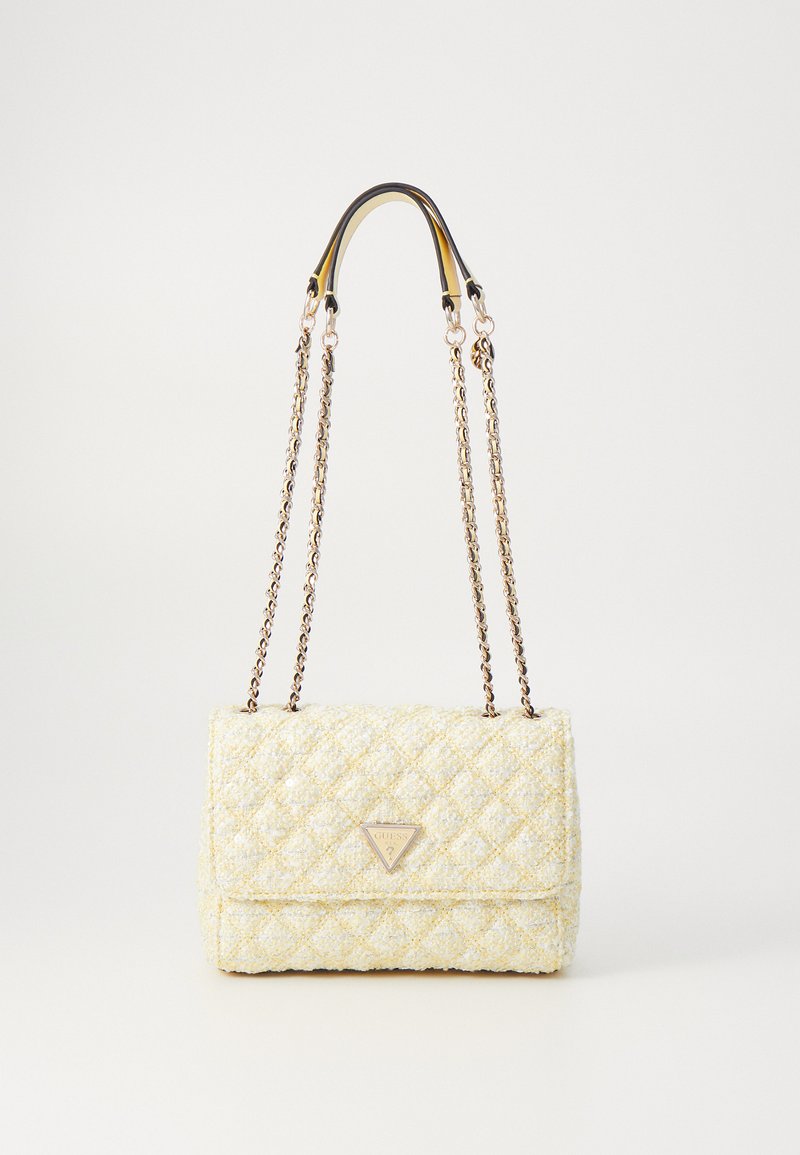 Bolso de tela acolchada amarilla con herrajes en tono plateado, asas de cadena dobles y placa con el logo en la parte frontal. Presenta una forma rectangular y un acabado texturizado.