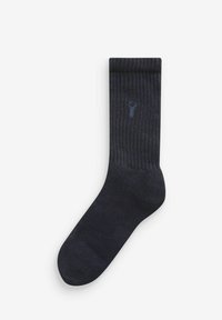 Calzino a coste blu scuro con una texture liscia e un piccolo, discreto logo sul lato. Cuffia elastica nella parte superiore.