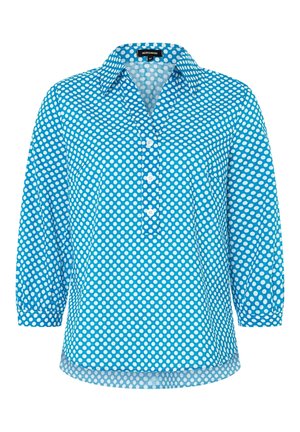Chemise bleu à boutons avec des pois blancs, dotée d'un col, de manches trois-quarts et d'une poche avant. Fabriquée en tissu léger.