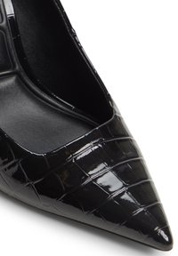 Zwarte gelakte leren pumps met een spitse neus, gekenmerkt door een krokodillenstructuur, een stijlvolle omtrek en een gladde binnenvoering. Geen zichtbare hardware.