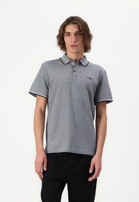 Grå polo-shirt lavet af bomuld med krave, to knapper og kontrastfarvede sorte striber på kraven og ærmerne.