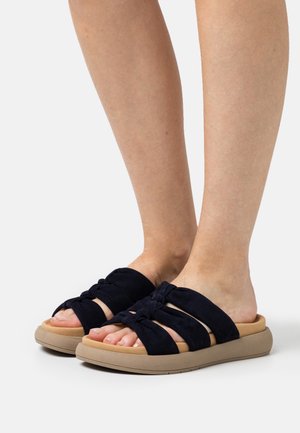 Sandales à glisser en suède bleu marine avec trois bandes nouées, semelle rembourrée beige et design à bout rond. Texture lisse et ajustement flexible.
