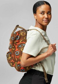 Brauner Stoff-Rucksack mit bunten kreisförmigen Mustern, verstellbaren Trägern, einem oberen Griff und zwei Seitentaschen.