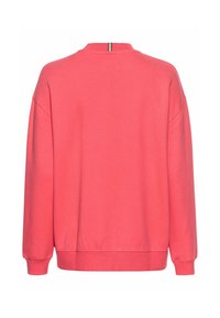 Korallenfarbener Pullover mit Rundhalsausschnitt, überschnittenen Schultern und gerippten Bündchen. Der Rücken weist einen dezenten gestreiften Akzent am Halsauschnitt auf.