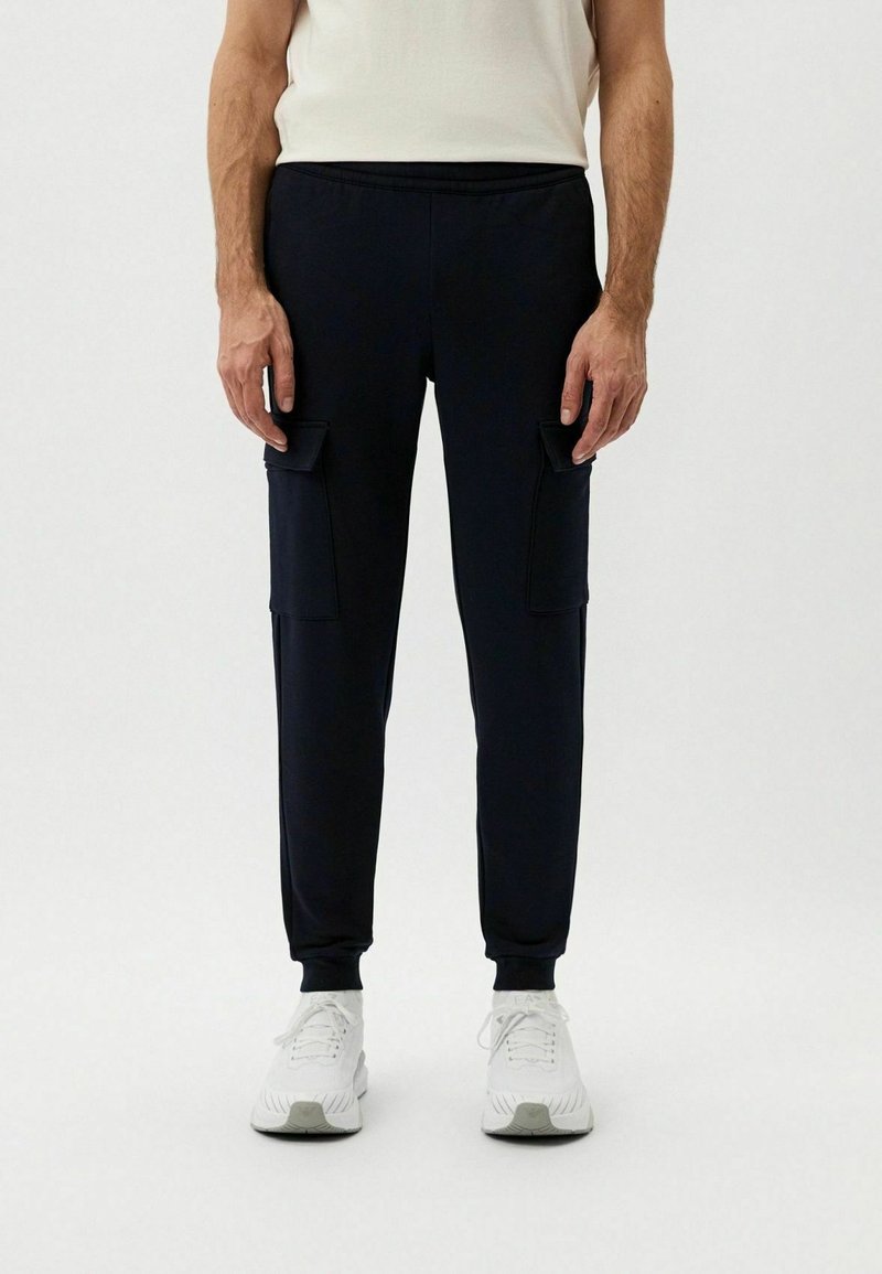 Pantaloni jogger navy realizzati in tessuto morbido, con tasche cargo laterali, polsini elasticizzati e cintura con cordino per una vestibilità regolabile.