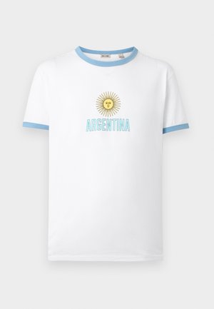 Bijela majica s svijetloplavim ovratnikom i rubovima rukava, s žutim suncem s licem i tekstom "ARGENTINA" u svijetloplavoj boji ispod.