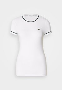 Weißes T-Shirt mit kurzen Ärmeln und grünen gerippten Akzenten am Kragen und an den Ärmeln, mit einem kleinen grünen Lacoste-Logo auf der linken Brust.