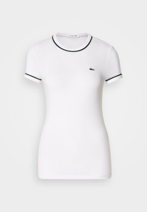 Biała koszulka z krótkim rękawem z zielonymi akcentami z prążkowanej tkaniny przy kołnierzyku i rękawach, z małym zielonym logo Lacoste po lewej stronie na piersi.