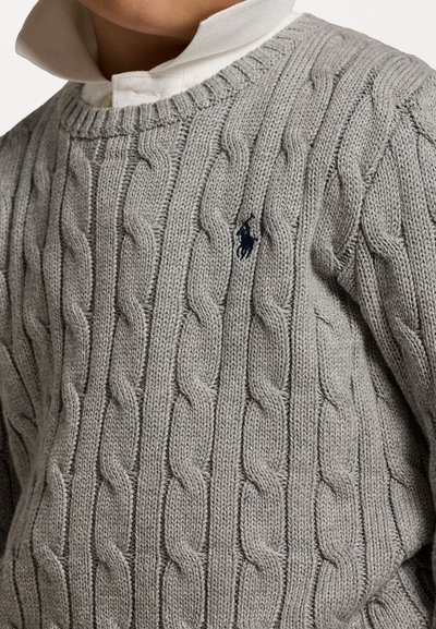 Šedý pletený sveter s káblovým vzorom, kruhovým výstrihom a námorníckou logom ako akcentom. Navrhnutý s textúrovanými detailmi a rebrovaným golierom.