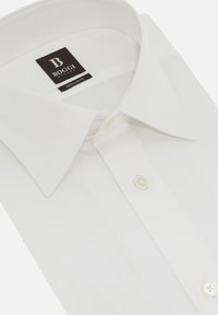 Camicia bianca in cotone, con colletto classico, vestibilità regolare e cuciture sottili. Due bottoni al collo con etichetta.