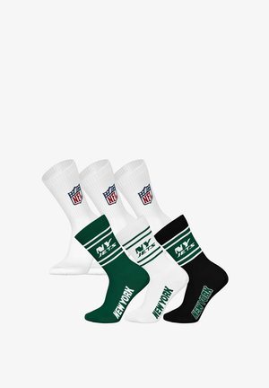 Tres pares de calcetines: dos blancos, uno verde, uno negro. Cada par presenta el logo de la NFL, el texto "NY JETS" o "NEW YORK", y acentos a rayas.