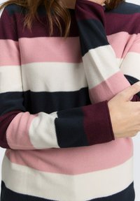 Maglione a righe caratterizzato da larghe bande di blu navy scuro, bordeaux, rosa chiaro e bianco. Tessuto testurizzato con polsini a coste e design a girocollo.