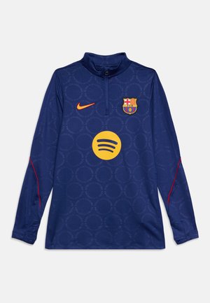Haut d'entraînement bleu à manches longues du FC Barcelone avec logo Nike orange et emblème jaune du sponsor Spotify à l'avant, présentant des motifs circulaires subtils.