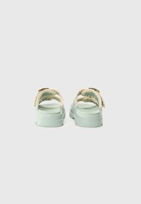 Mint green sandals with braided light tan straps, featuring a thick, textured sole and adjustable buckle accents. Back view displayed.