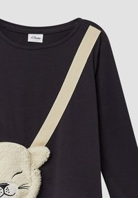 Czarny top z długim rękawem z beżowym paskiem na ramieniu. Dołączona jest miękka kieszonka w kształcie misia z zamkiem błyskawicznym, z czarnymi detalami twarzy.