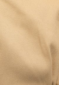 Tessuto beige con una superficie testurizzata caratterizzata da un fine motivo a coste, che indica un materiale resistente adatto a diverse applicazioni.