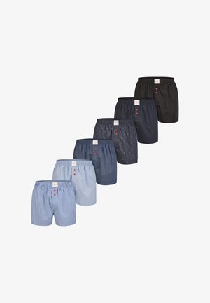 Assortiment de boxers pour hommes dans diverses couleurs : rayé bleu clair, uni bleu clair, marine à pois blancs, uni noir, uni bleu marine foncé, avec des boutons rouges.