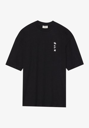 Svart bomulls t-skjorte med korte ermer, rund hals og et lite hvitt grafisk design på venstre side med tekst og blomster elementer.