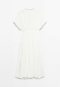 Robe midi blanche à manches courtes, tissu froissé, taille élastique, et bordure contrastante noire aux manches, à l'encolure et à l'ourlet.