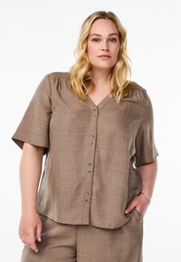 Brown, short-sleeved blouse with a V-neck and button front. Made from a textured fabric, featuring a relaxed fit and a slightly curved hem.