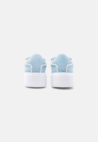Ανοιχτό μπλε σουέντ αθλητικά παπούτσια με παχύ λευκό καουτσούκ σόλα· διαθέτουν ραμμένες λεπτομέρειες και λογότυπο στη φτέρνα.