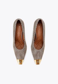 Czółenka na cienkim obcasie z metalicznej tkaniny, z charakterystycznym przodem w kolorze złotym oraz subtelną pikowaną fakturą wewnątrz. Brązowa skórzana wkładka.