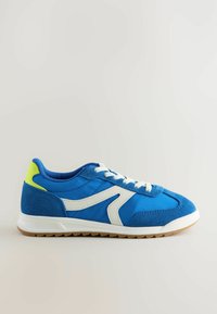 Baskets de sport bleues en matériaux en daim et en tissu, avec des accents blancs et un talon vert citron. Dispose d'un design à lacets et d'une semelle texturée.