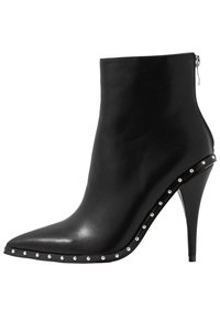 Musta nahkasaapas nilkkapituudella, terävä kärki, stiletto-korko, pystysuora vetoketju ja hopeiset niitit sivuilla lisäyksinä.