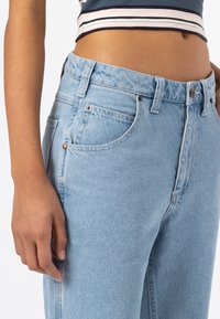 Světlé modré džíny z denimu s vysokým pasem, pětikusovým designem a jemným vyblednutím. Vyrobené z texturované bavlněné tkaniny s kovovými prvky.