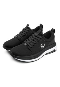 Schwarze Sportschuhe mit einem weichen, strukturierten Obermaterial, Schnürverschluss, weißer Zwischensohle und transparenten Dämpfungselementen an der Ferse.