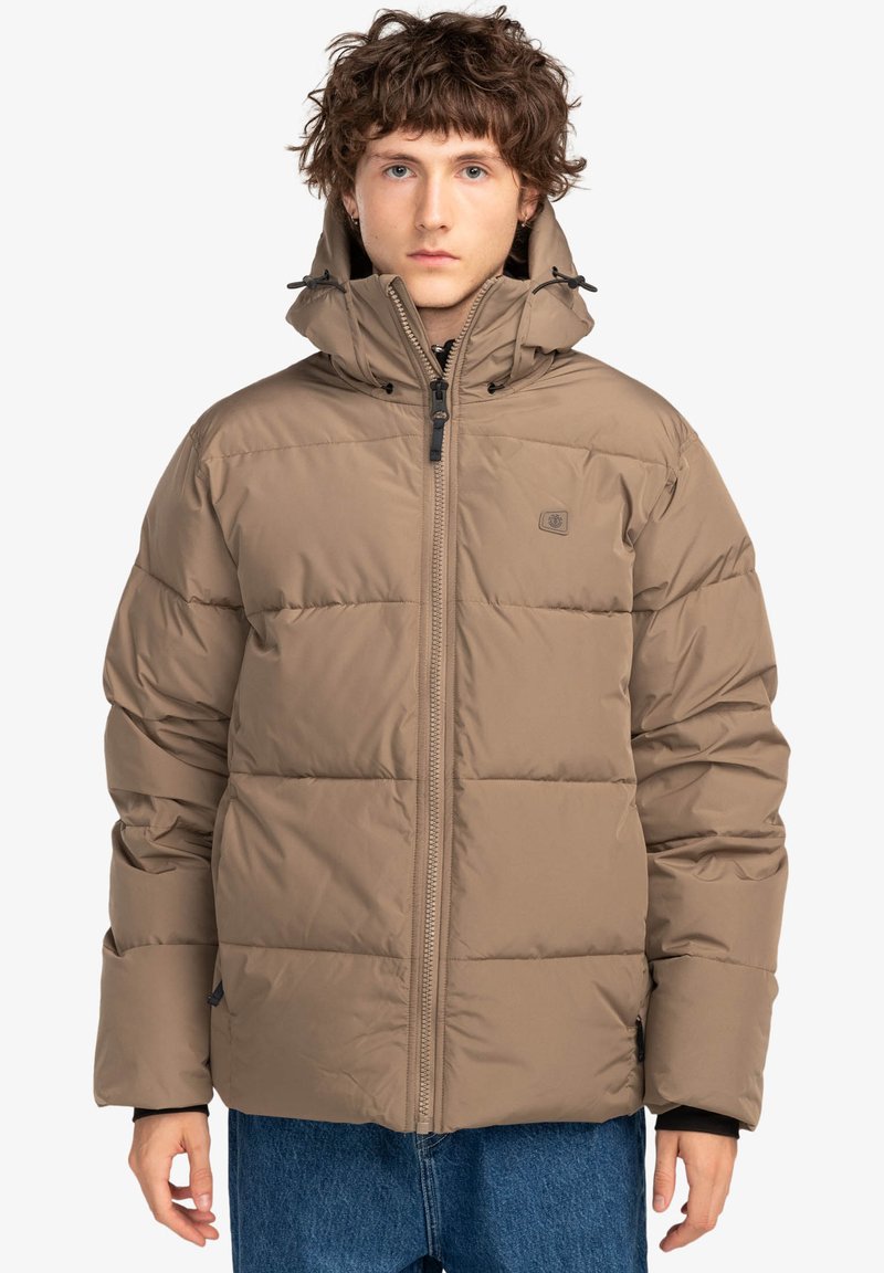 Giacca puffer beige con colletto alto, zip frontale e cordini sul cappuccio. Presenta sezioni trapuntate e un logo discreto sul petto.