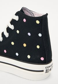 Zwarte hoge sneakers met meerkleurige stippen, van canvas materiaal, met witte veters en een gestructureerde rubberen zool met een zwart-witte streep.