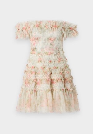 Vestido sin mangas en color crema claro con volantes en capas y detalles florales en rosa. Presenta bandas elásticas fruncidas para un aspecto texturizado.