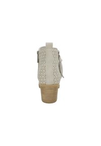 Beige ankelstøvle med perforeret design, baglynlås og en træstak hæl. Har en sløjfeaccent på siden for detaljer.