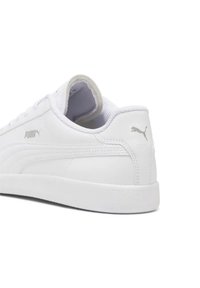 White Puma sneaker with a smooth leather upper, textured sides, and a rubber sole. Features a silver Puma logo on the heel and side.
