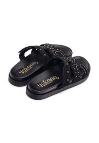 Infradito in suede nero con dettagli in oro, dotati di due ampie cinghie e suola nera imbottita. Il logo "Yokono" appare all'interno.