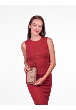 Brown crossbody phone bag with textured holes, cream accents, and a circular logo. The bag features a strap for convenience.