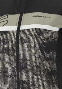 Herrcykeljacka i svart och grått, med ett strukturerat mönster, vita ränder och en framträdande "ENDURANCE"-logotyp på bröstet.