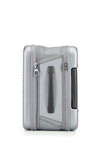 Valigia rigida argentea con finitura testurizzata, dotata di cerniera, maniglia laterale e una sezione in tessuto grigio a contrasto con un motivo lineare.